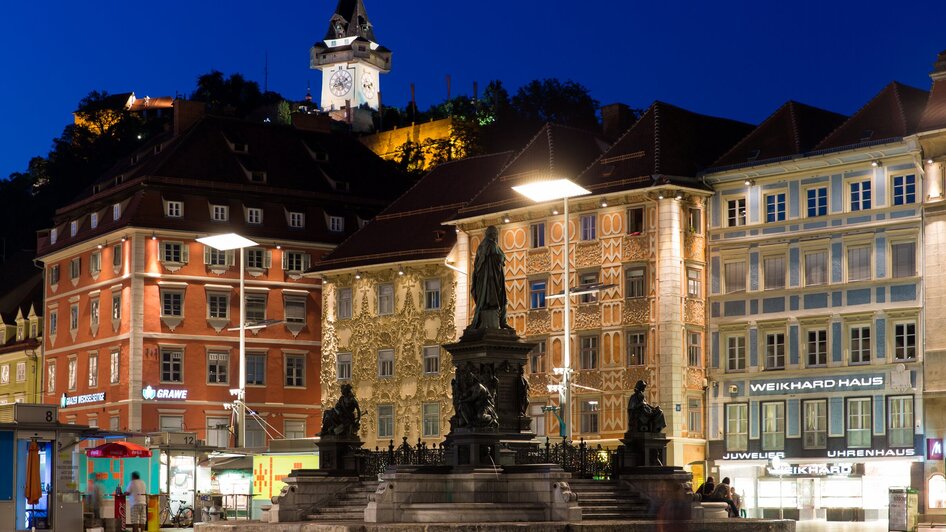 Der Grazer Hauptplatz bei Nacht mit Blick auf den Brunnen und den Uhrturm