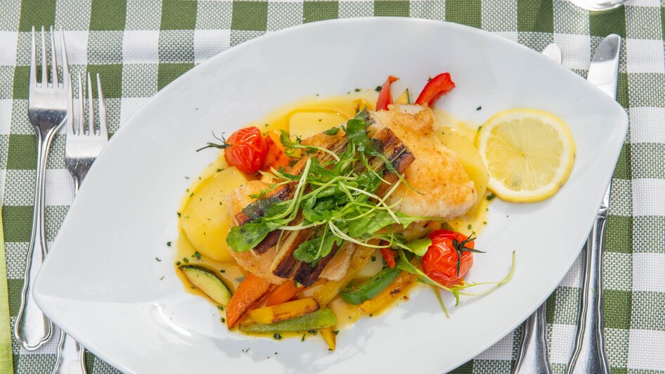 Gegrillter Fisch auf einem Teller mit Gemüse und Kirschtomaten. | © 5komma5sinne - Helmut Schweighofer