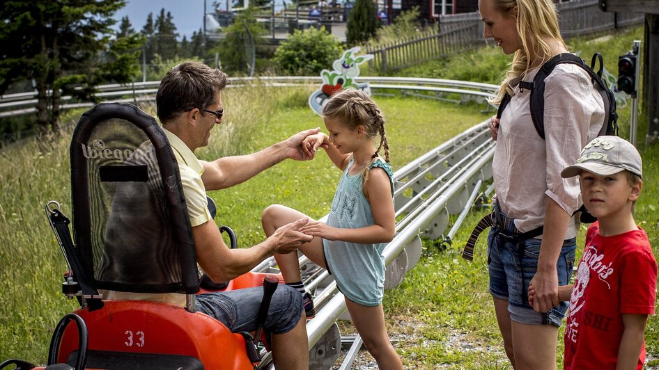 Familie bereitet sich auf eine Sommerrodelbahnfahrt vor | © Region Graz - Tom Lamm