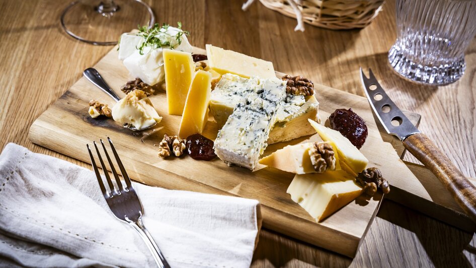 Eine Holzplatte mit verschiedenen Käsesorten, Nüssen und Marmelade. | © Kaiser Greissler - Werner Krug