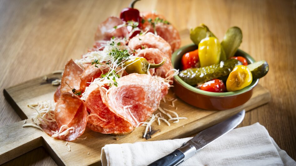 Platte mit Salami, Käse, Gurken und Peperoni auf Holzbrett. | © Kaiser Greissler - Werner Krug