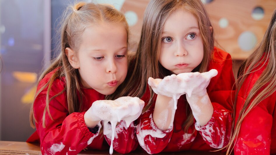 Mädchen machen Seifenblasen - in der Ausstellung "Seifenblasen Träume" im Kindermuseum FRida & freD