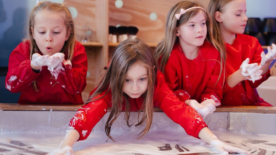 Mädchen machen Seifenblasen - in der Ausstellung "Seifenblasen Träume" im Kindermuseum FRida & freD