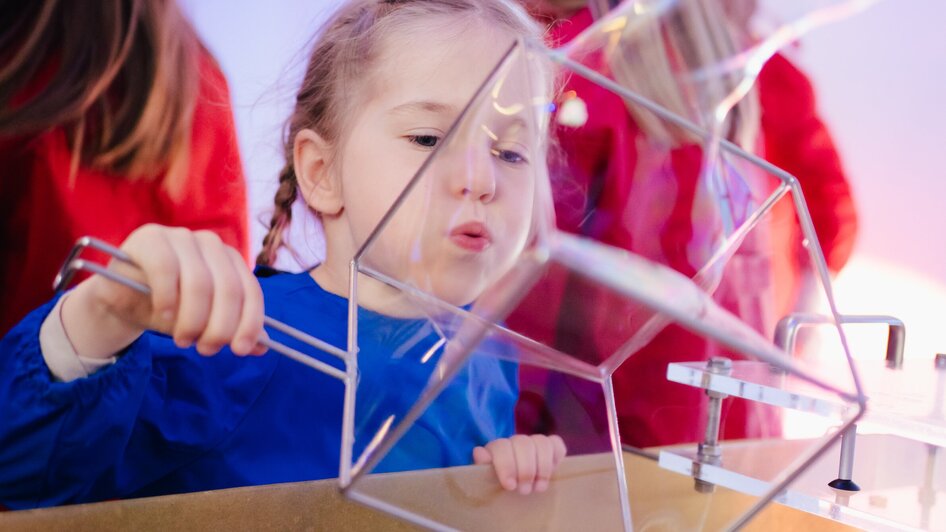 Mädchen macht Seifenblasen - in der Ausstellung "Seifenblasen Träume" im Kindermuseum FRida & freD