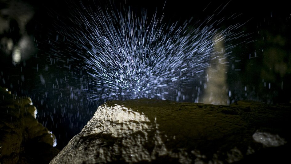 Spritzendes Wasser in der Lurgrotte Semriach über einem Felsen. | © Region Graz - Tom Lamm