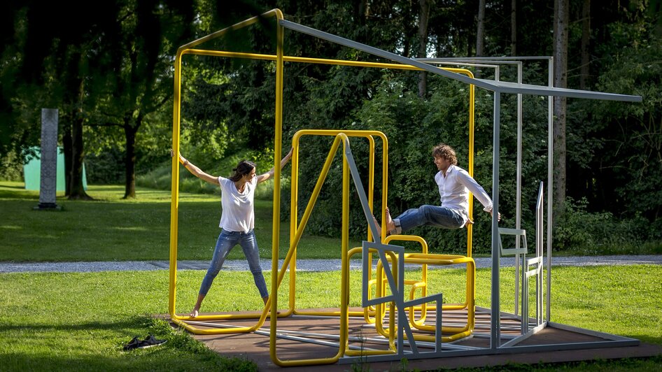 Zwei Personen spielen in einer kreativen Skulptur im Österreichischen Skulpturenpark. | © Region Graz - Tom Lamm
