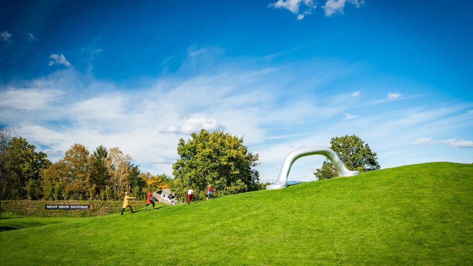Eine Gruppe von Menschen im Österreichischen Skulpturenpark auf einem Hügel. | © Region Graz - Mias Photoart